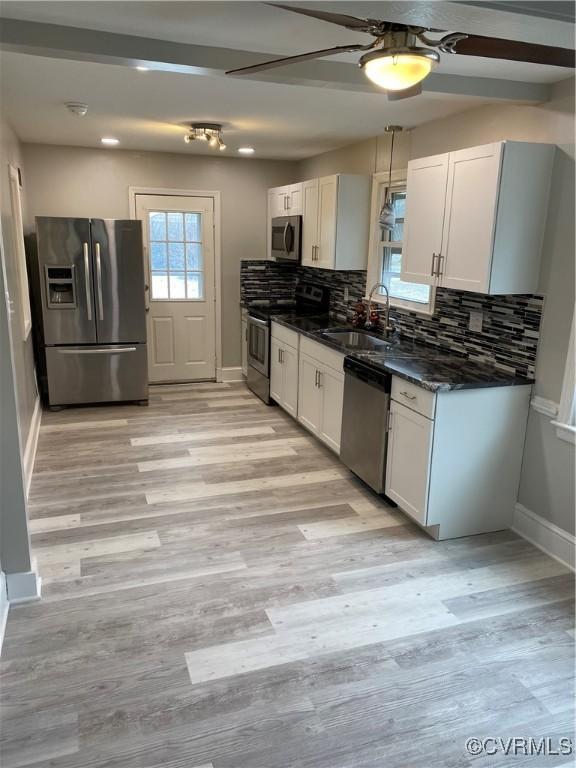 kitchen featuring ceiling fan, white cabinetry, appliances with stainless steel finishes, and tasteful backsplash