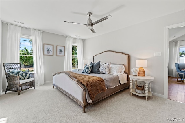 bedroom featuring multiple windows, ceiling fan, and light wood-type flooring