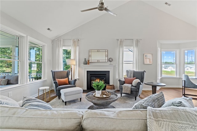 living room featuring light wood-type flooring, high vaulted ceiling, and ceiling fan