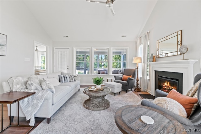 living room featuring ceiling fan, light hardwood / wood-style floors, and vaulted ceiling