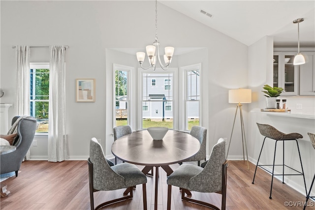 dining area with a healthy amount of sunlight, lofted ceiling, and hardwood / wood-style floors