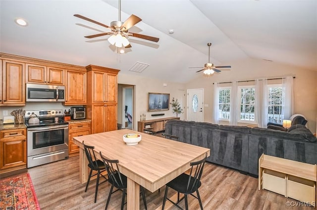 kitchen featuring hardwood / wood-style floors, stainless steel appliances, and lofted ceiling