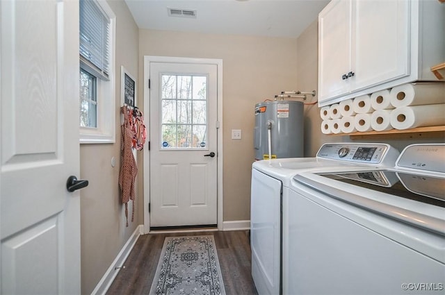 laundry area featuring washing machine and dryer, electric water heater, dark hardwood / wood-style flooring, and cabinets