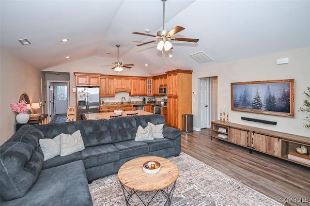 living room featuring ceiling fan, sink, hardwood / wood-style floors, and lofted ceiling