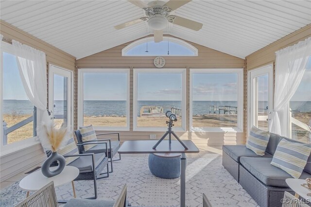 sunroom / solarium with ceiling fan, a water view, and lofted ceiling