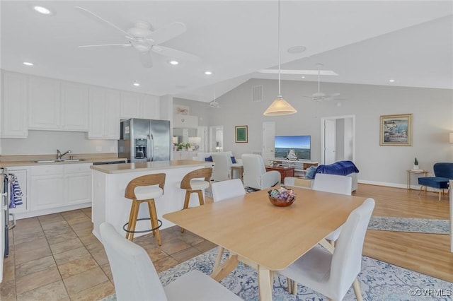 tiled dining area with ceiling fan, lofted ceiling, and sink