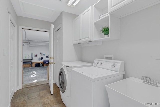 laundry area featuring washing machine and dryer, sink, and cabinets