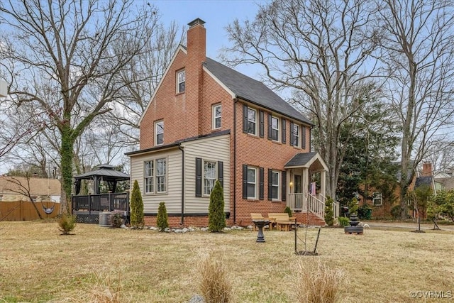 view of side of property featuring a gazebo, a yard, and central AC unit