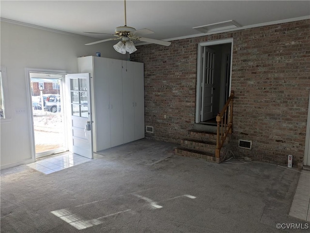 spare room with carpet, ornamental molding, and ceiling fan