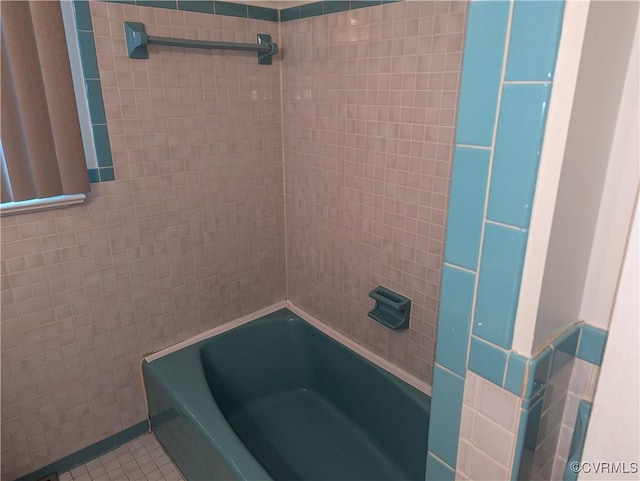 bathroom with tile patterned floors and washtub / shower combination