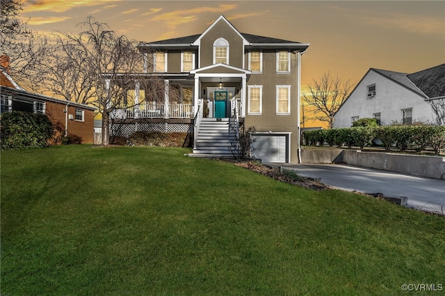 view of front of house featuring a lawn, a porch, and a garage