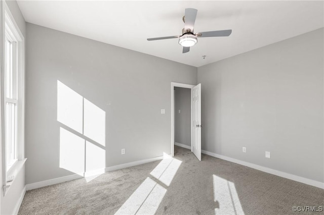 unfurnished room with ceiling fan and light carpet