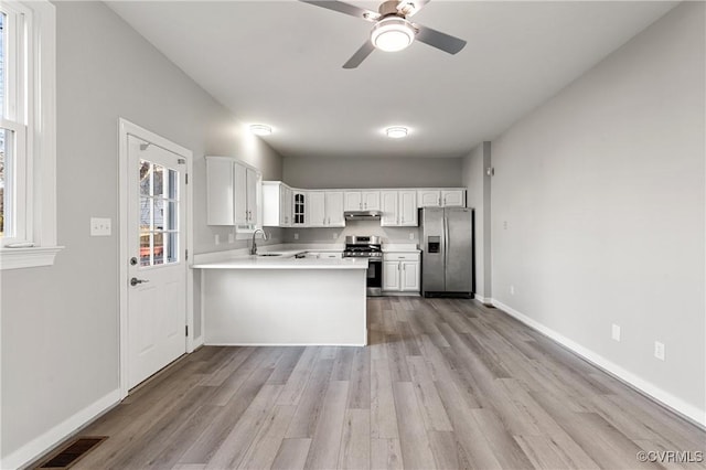 kitchen featuring white cabinetry, sink, ceiling fan, stainless steel appliances, and kitchen peninsula