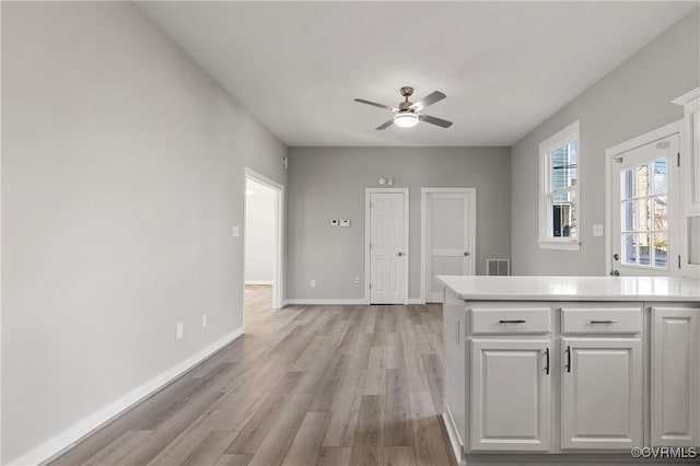 kitchen featuring ceiling fan, light hardwood / wood-style flooring, and white cabinets