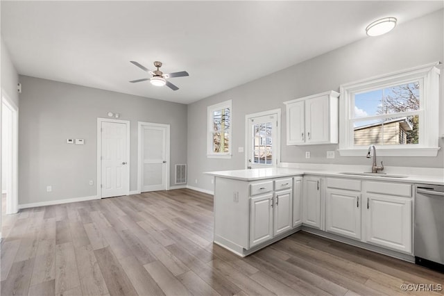 kitchen featuring ceiling fan, dishwasher, sink, kitchen peninsula, and white cabinets