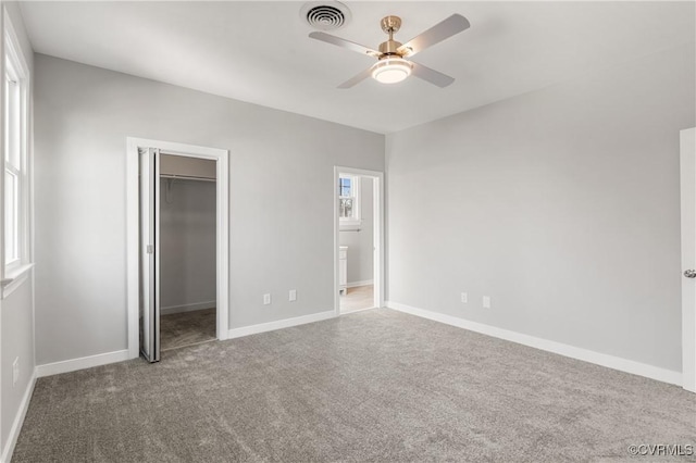 unfurnished bedroom featuring ceiling fan, a closet, carpet floors, and a spacious closet