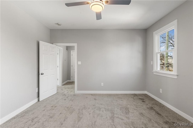 carpeted spare room with ceiling fan