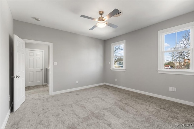 carpeted spare room with plenty of natural light and ceiling fan