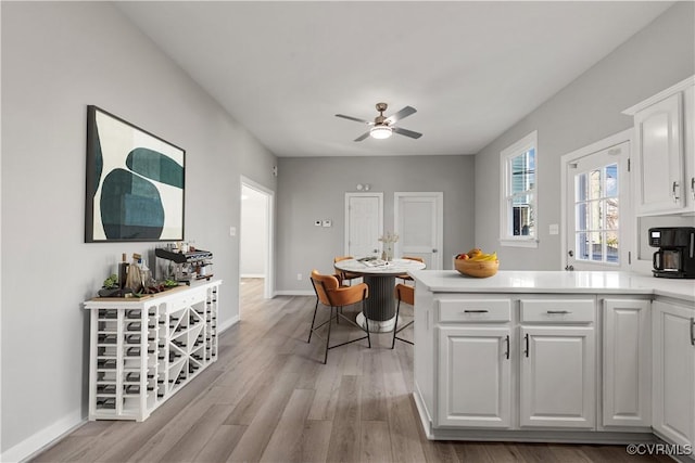 kitchen with white cabinetry, ceiling fan, and light wood-type flooring