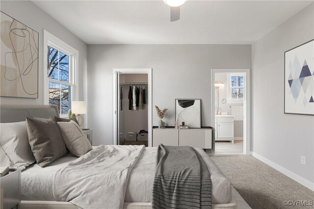 carpeted bedroom featuring ceiling fan, a closet, a spacious closet, and ensuite bath