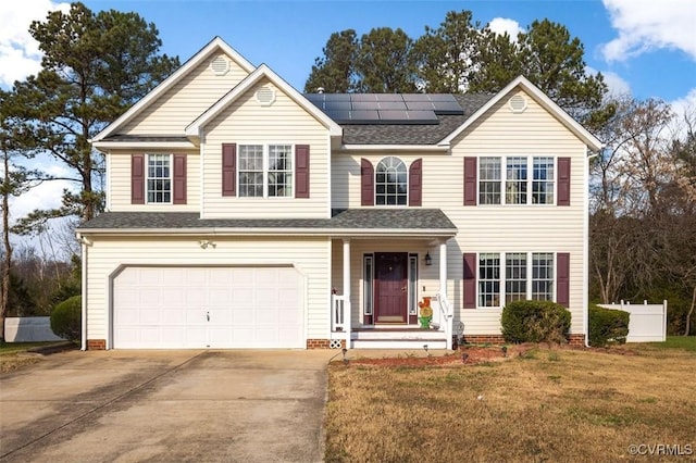 view of front of house with solar panels, a garage, and a front yard