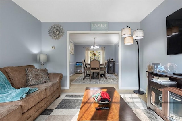 living room featuring baseboards, crown molding, and a chandelier