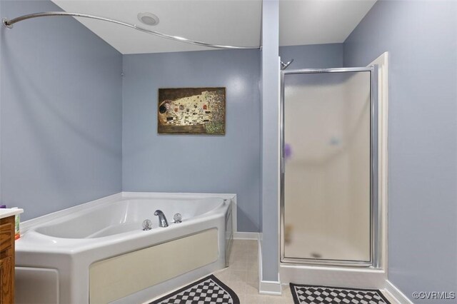 bathroom with tile patterned floors, baseboards, a shower stall, and a garden tub