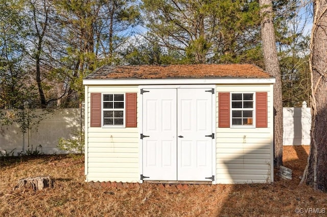 view of shed featuring fence