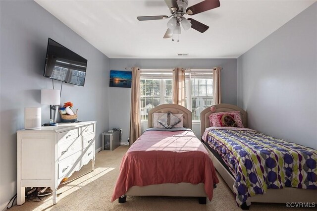 bedroom featuring baseboards, ceiling fan, visible vents, and light colored carpet