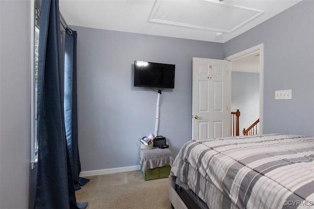 bedroom featuring baseboards, carpet flooring, and attic access