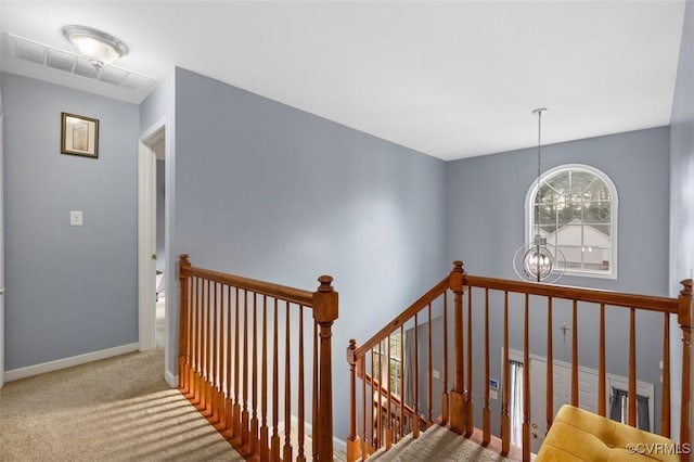 staircase featuring baseboards, carpet, and a chandelier