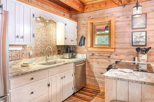 bathroom featuring beam ceiling, vanity, hardwood / wood-style flooring, and wood walls