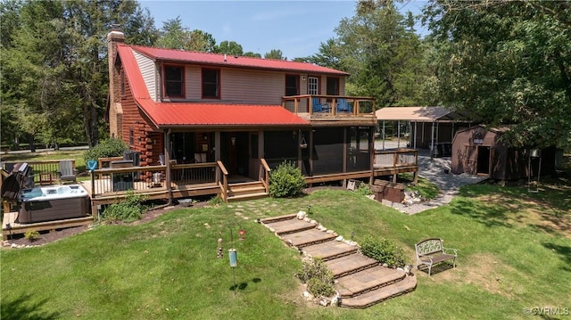 rear view of house with a hot tub, a lawn, and a sunroom