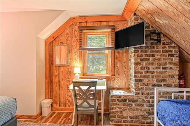 interior space with wood walls, lofted ceiling, and hardwood / wood-style flooring