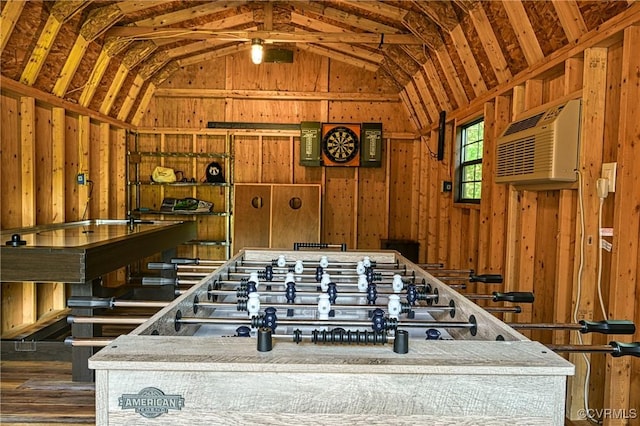 interior space with wood walls, dark hardwood / wood-style flooring, a wall mounted AC, and vaulted ceiling