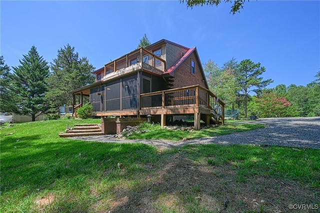 back of house featuring a sunroom and a lawn