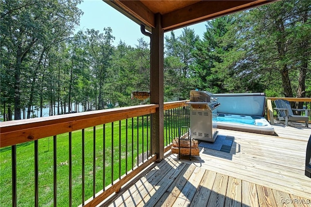 deck with a water view, a covered hot tub, and a lawn