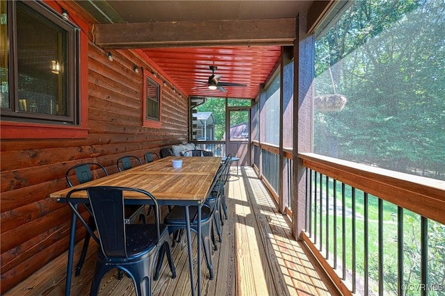 unfurnished sunroom featuring ceiling fan