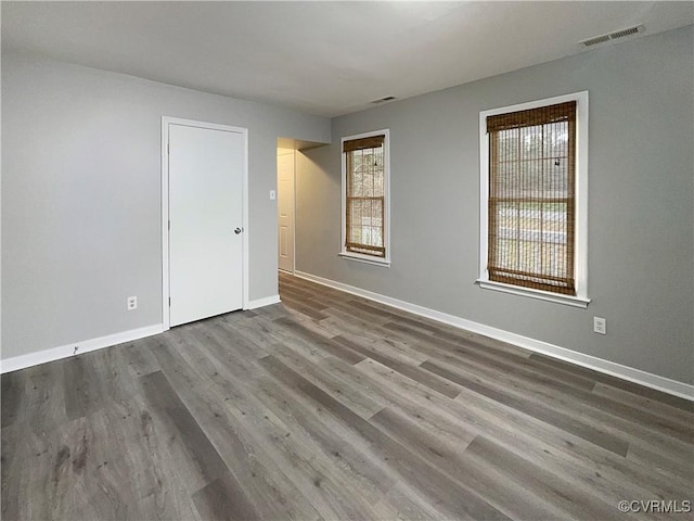 unfurnished room with hardwood / wood-style flooring and a healthy amount of sunlight