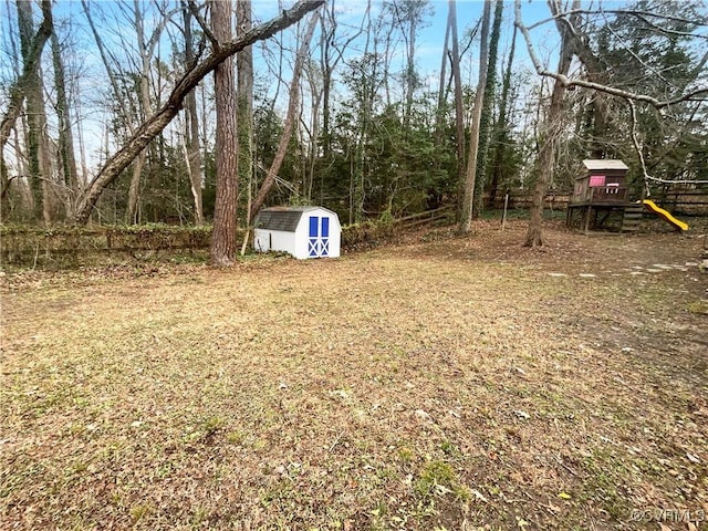 view of yard featuring a storage unit and a playground