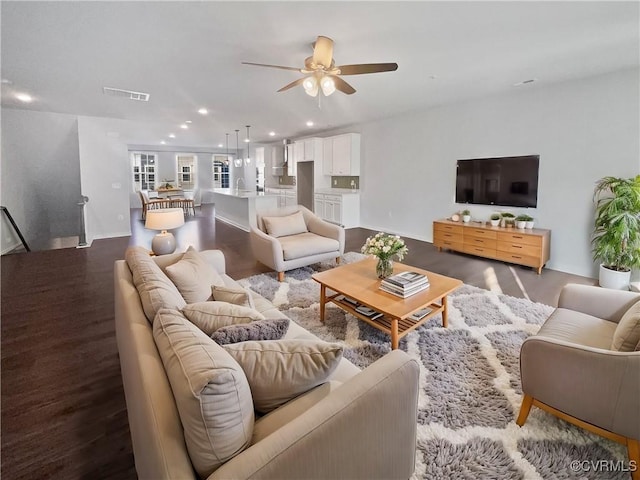 living room featuring hardwood / wood-style flooring, ceiling fan, and sink