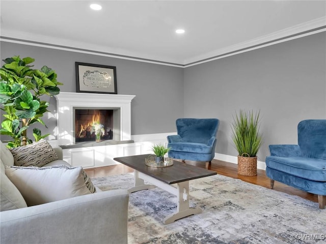 living area with hardwood / wood-style floors and ornamental molding