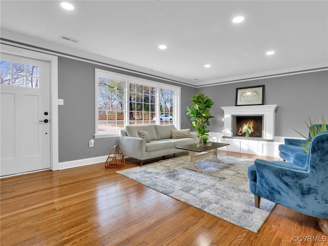 living room with hardwood / wood-style flooring and crown molding