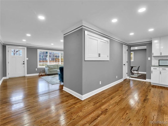 unfurnished living room featuring crown molding and hardwood / wood-style floors