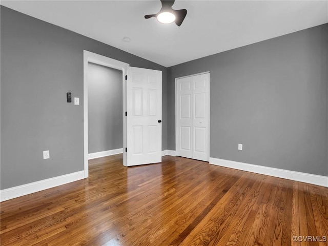 unfurnished bedroom with ceiling fan, wood-type flooring, and lofted ceiling