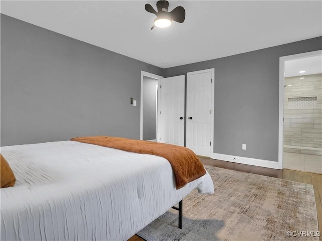 bedroom featuring ensuite bathroom, ceiling fan, and hardwood / wood-style flooring