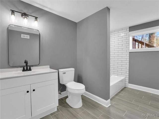 full bathroom featuring vanity, bathing tub / shower combination, and toilet