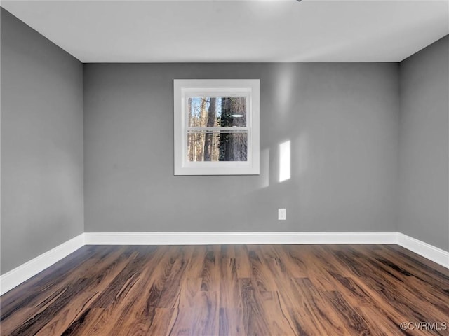 unfurnished room with dark wood-type flooring