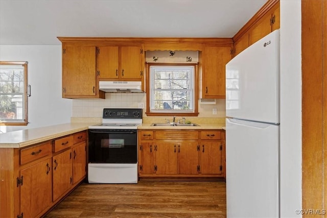 kitchen with decorative backsplash, kitchen peninsula, dark hardwood / wood-style flooring, white appliances, and sink