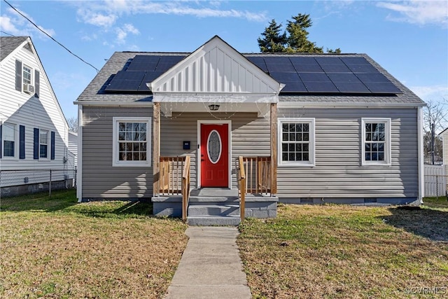 bungalow with solar panels and a front yard